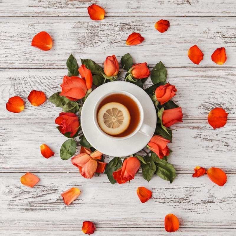 Открытка лепестки роз и чай с лимоном  фон из досок  Gute Besserung 