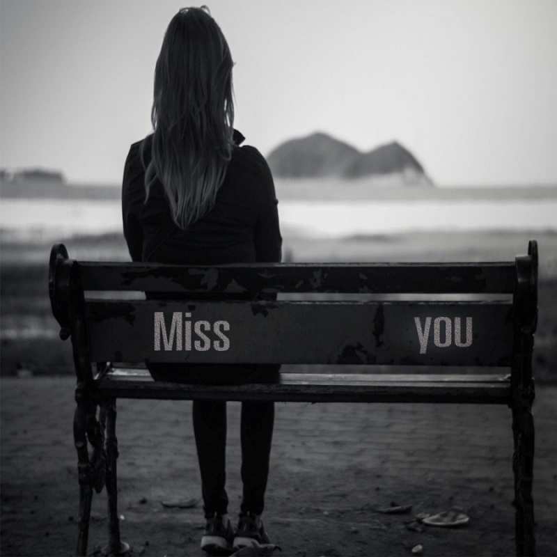 Открытка девушка сидит на лавочке на берегу моря  смотрит на скалы  Sei nicht traurig 