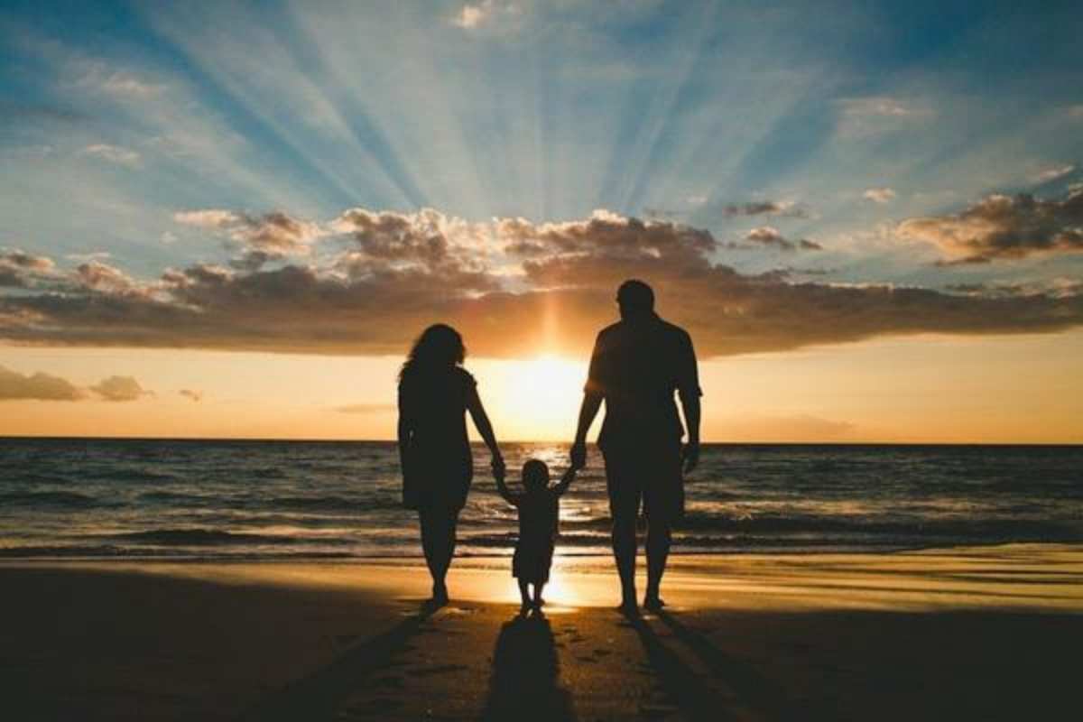 Открытка Мама и папа держат ребенка за руки. Закат на море, морской пляж  Море, пляж, закат, семья  Mit dem Familientag 